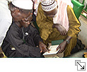 Zoom: Imame prüfen den Inhalt des Goldenen Buches sehr genau